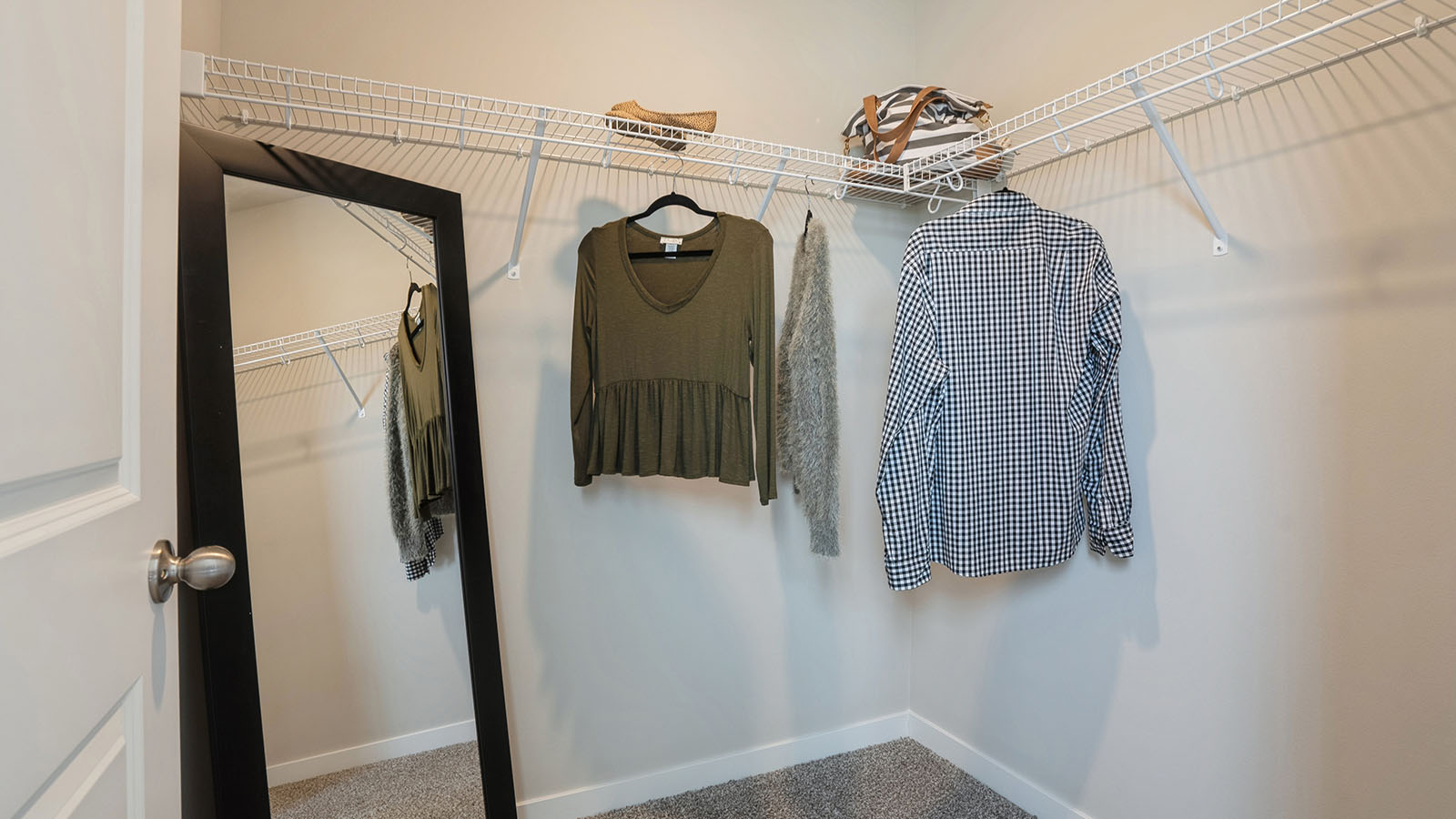 Large walk-in closet with shelving off primary bathroom