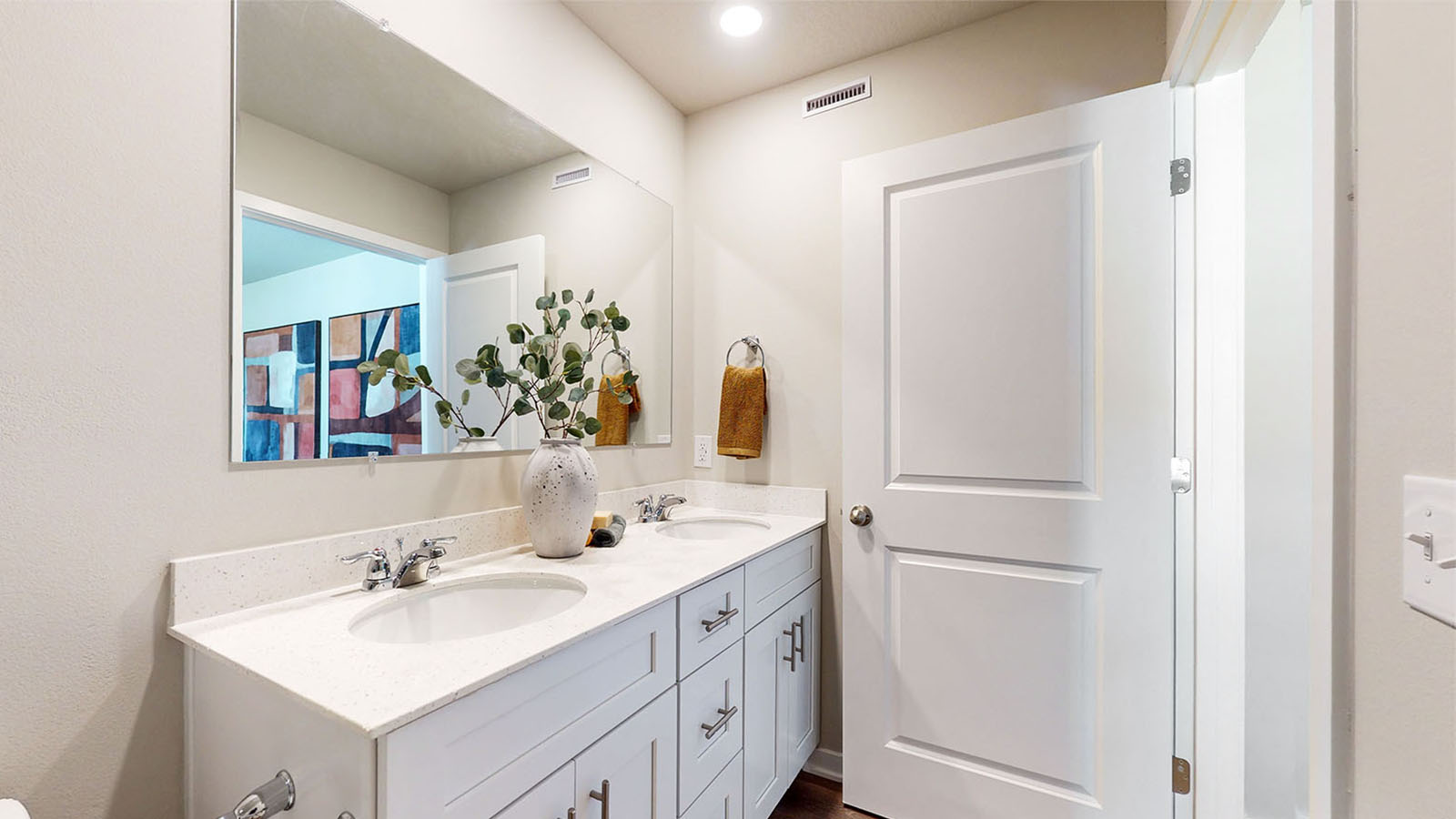 Second bedroom with mirror and white cabinets