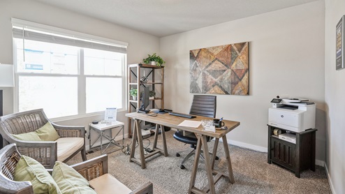 First bedroom staged as an office with large window
