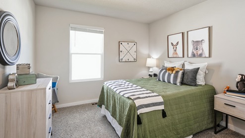 Second bedroom with small window and green bed