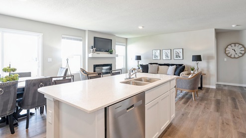 Kitchen island with sink and dishwasher overlooking living room
