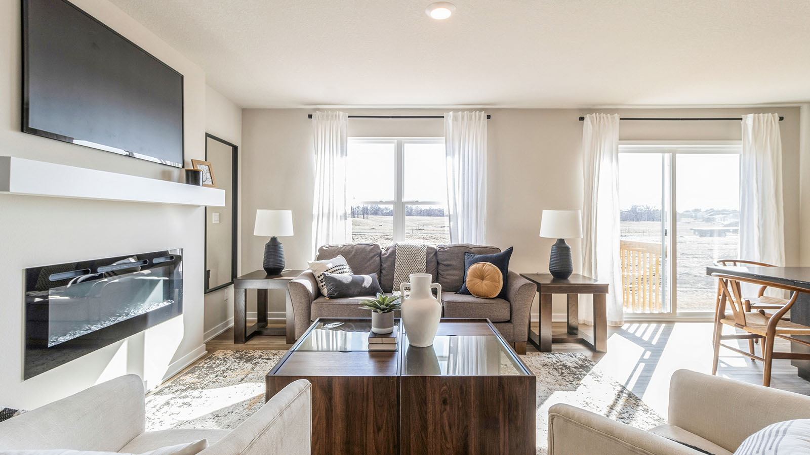 Modern living room in New Home For Sale by DR Horton offers backyard visibility and kitchen access