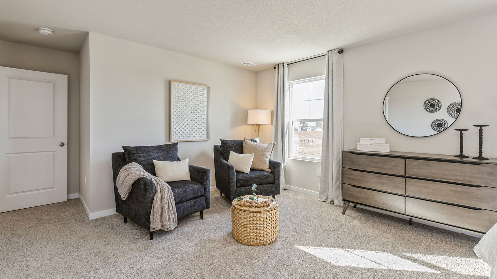 Bedroom featuring two black chairs, a dresser, and a window.