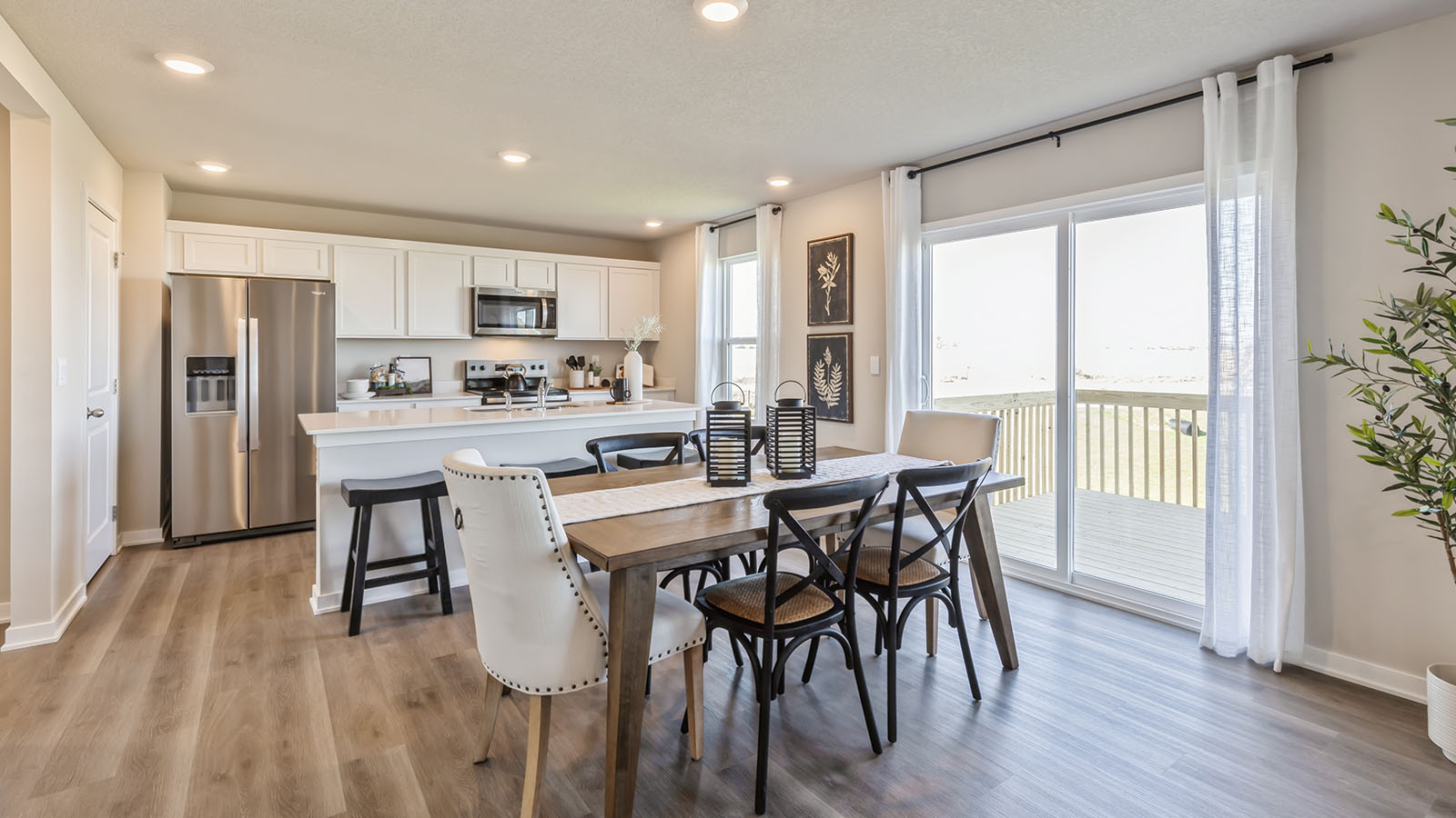 Dining area with a large wood table, six chairs, and a sliding door.