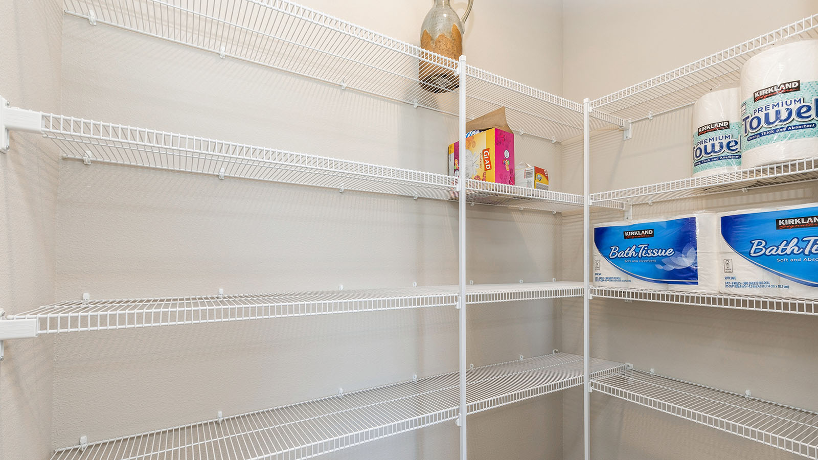 Large walk in pantry with white wire shelving.