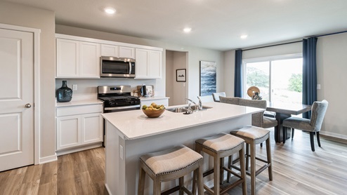 white kitchen with quartz countertops and island with barstools
