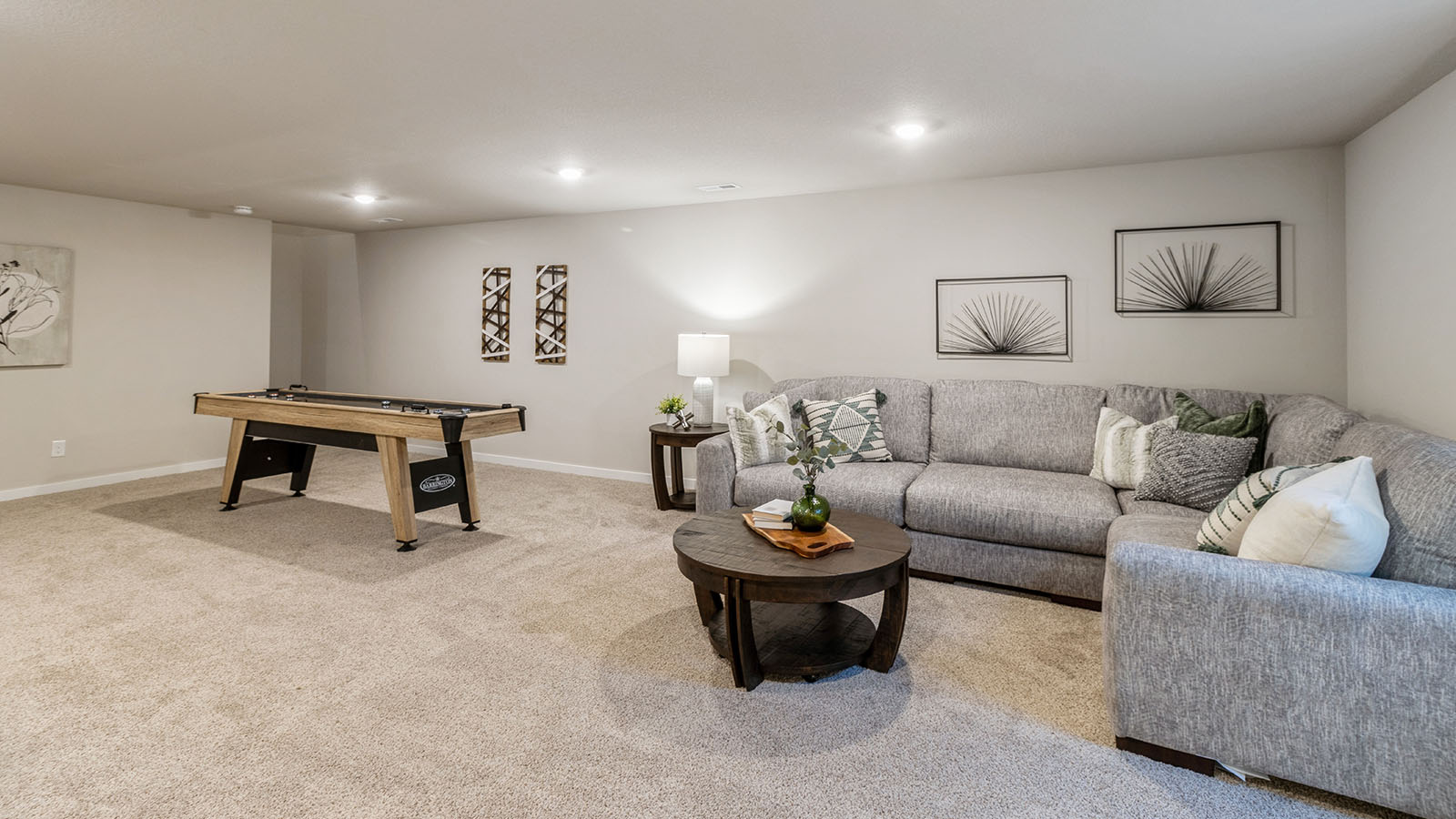Finished basement with grey couch and coffee table