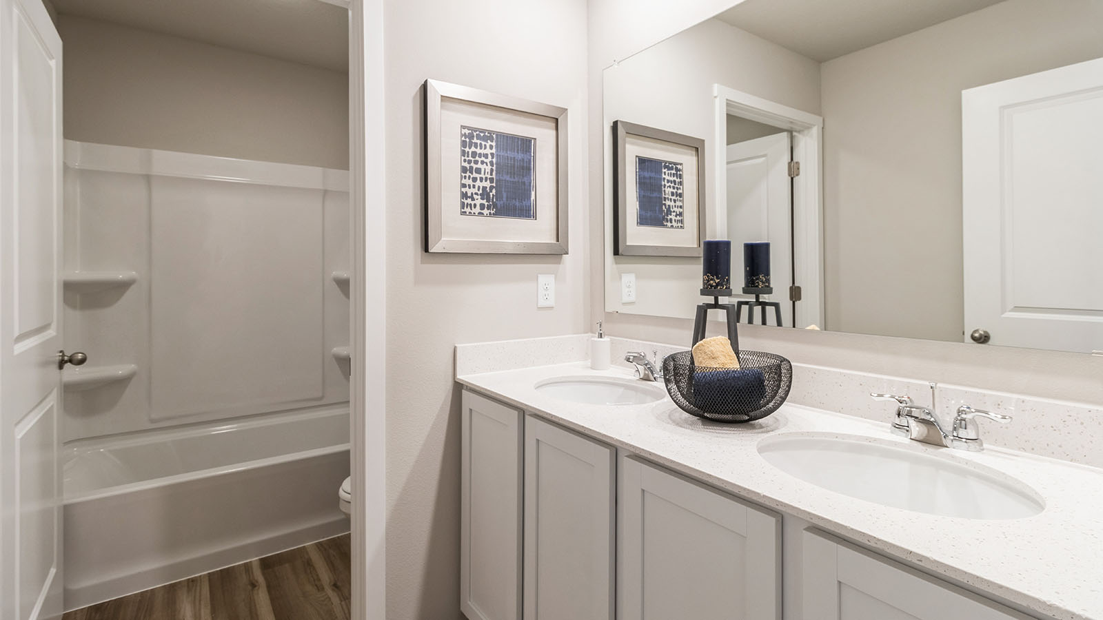 Second bathroom with bathtub and dual sinks with white cabinets
