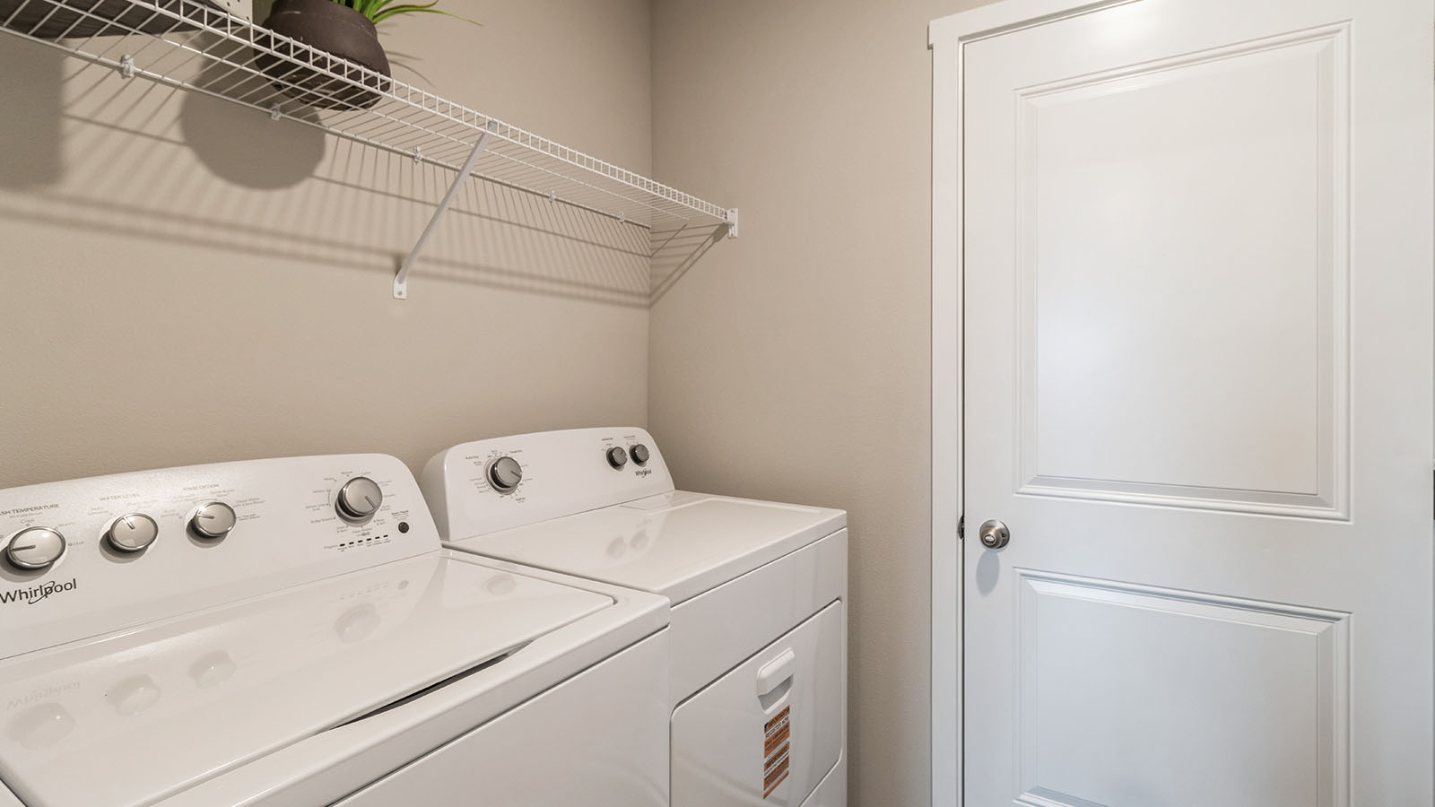 Washer and dryer with white wire shelving above