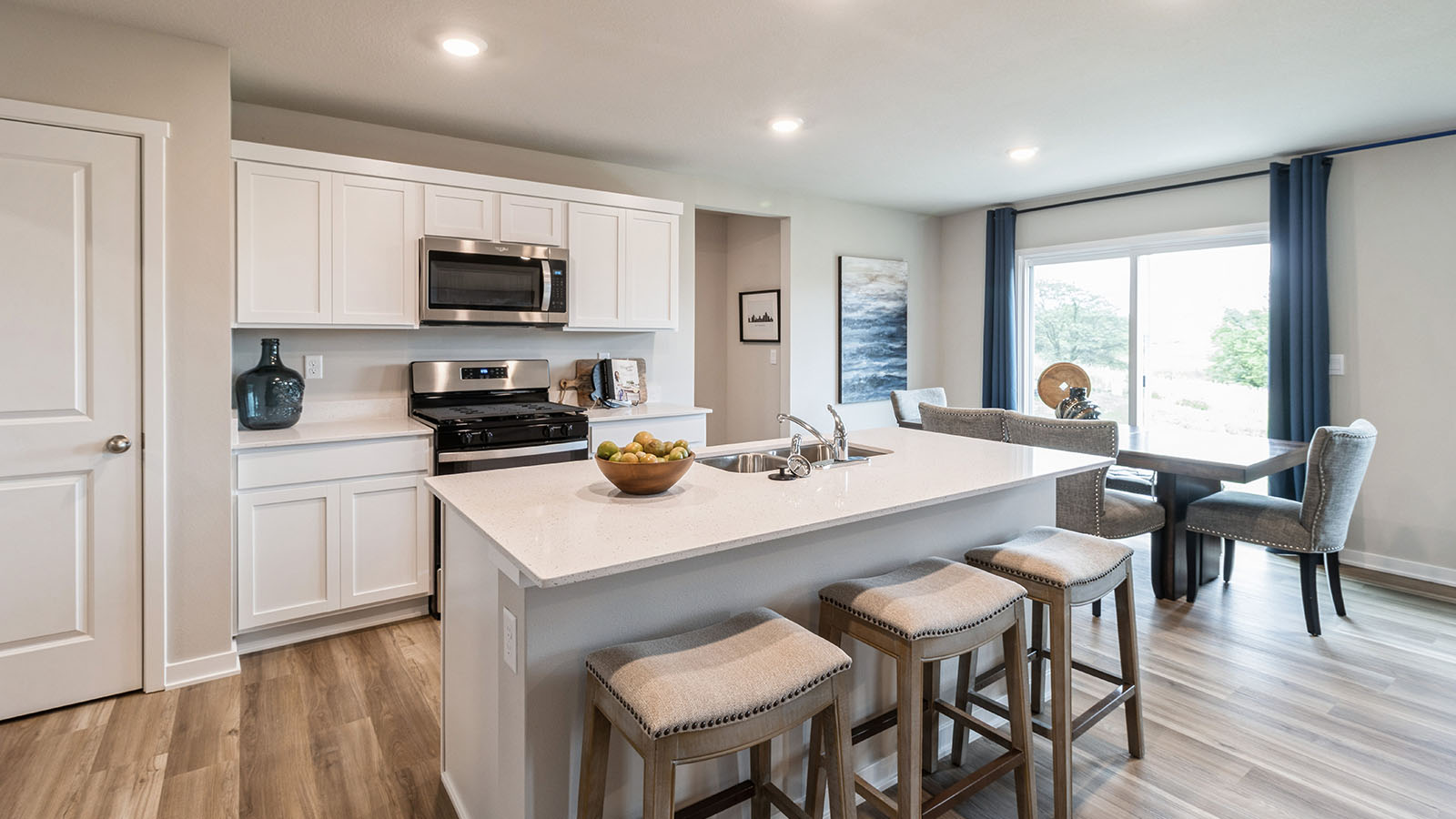 White kitchen with quartz countertops and island with barstools