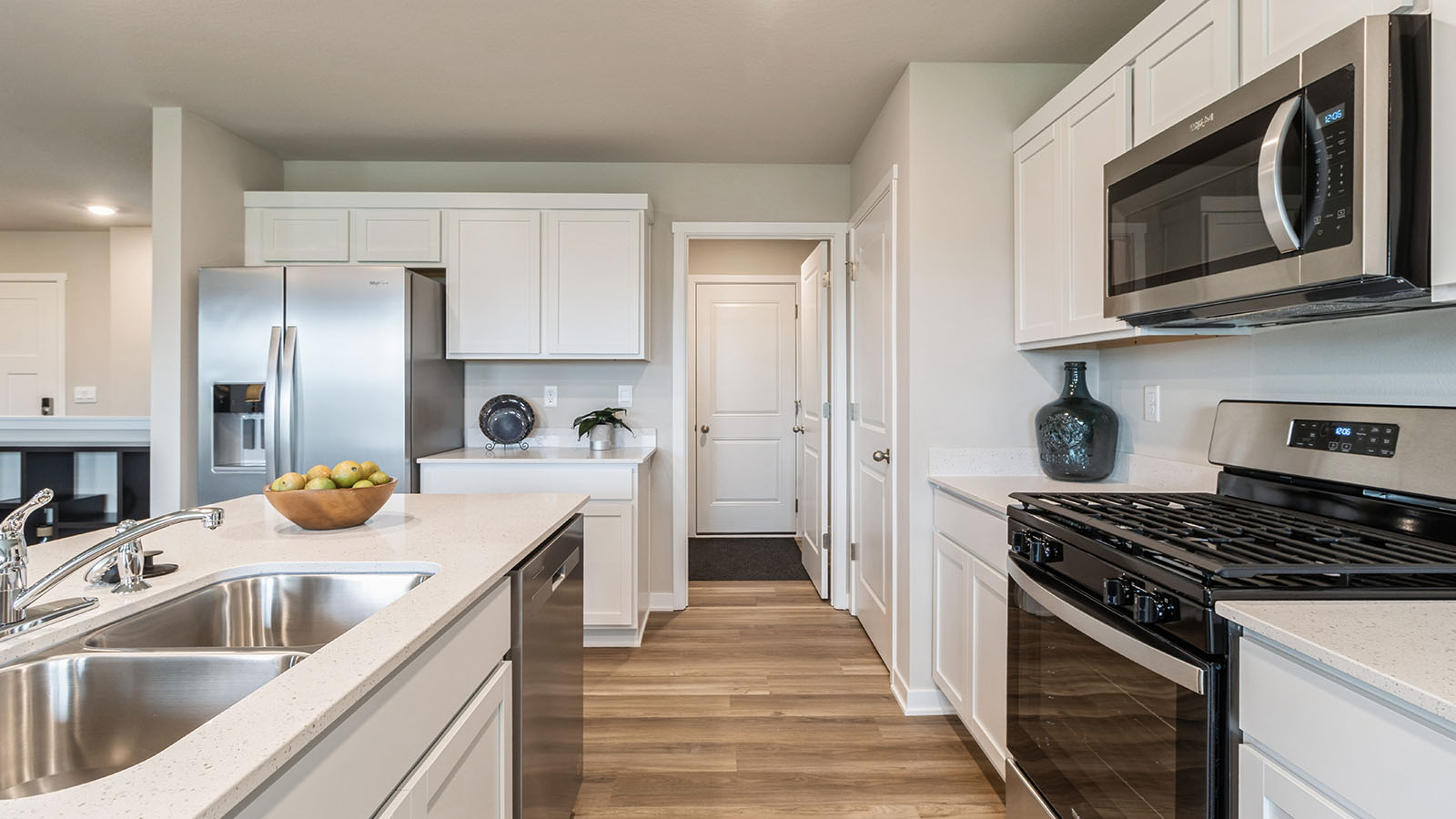 Side view of kitchen with white cabinets and stainless-steel appliances