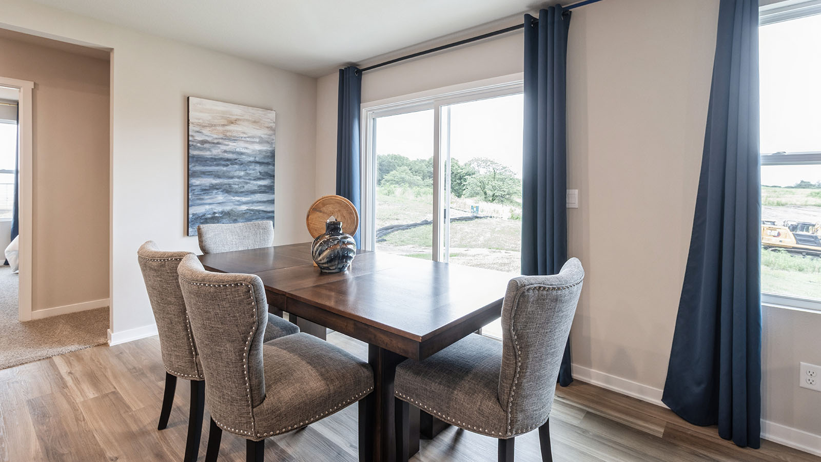 Dining area with wood table and grey chairs next to glass sliding doors