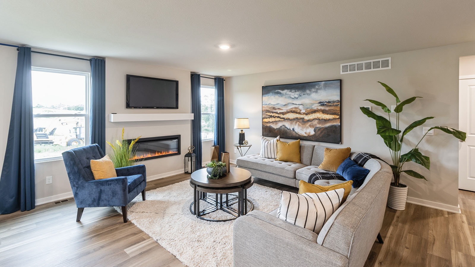 Large living room with two windows and electric fireplace and mounted tv