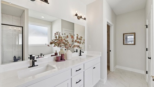 primary bathroom with large mirror and dual sinks