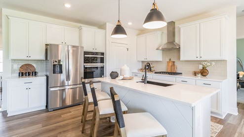 Modern and open kitchen with white cabinets and stainless-steel appliances