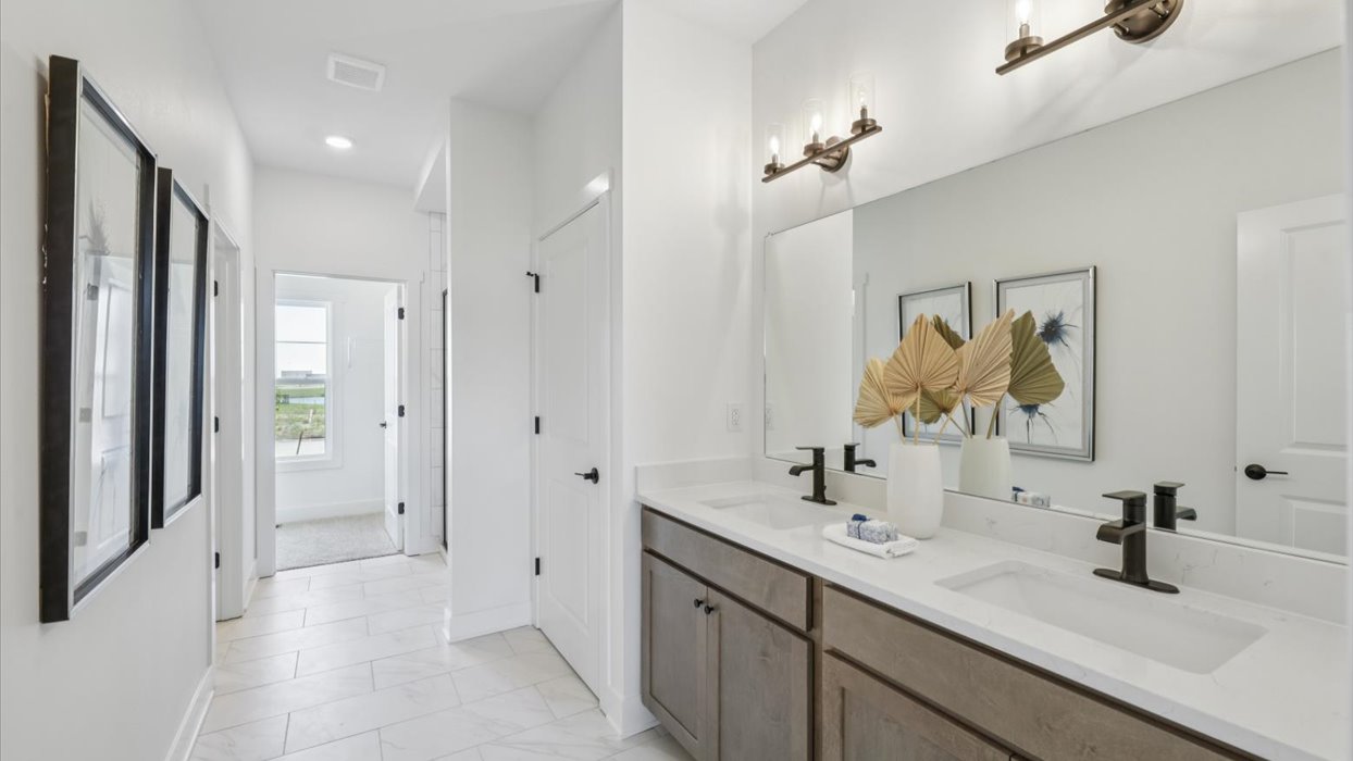 primary bathroom with large mirror and dual sinks