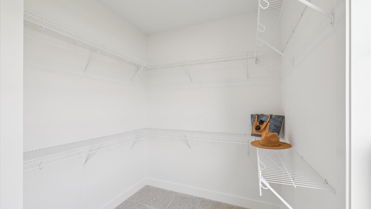 spacious walk-in closet with white shelving