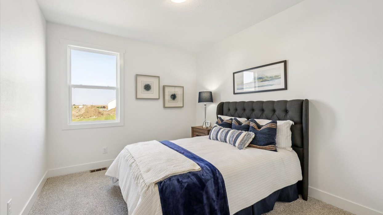 second bedroom with white bed and small window