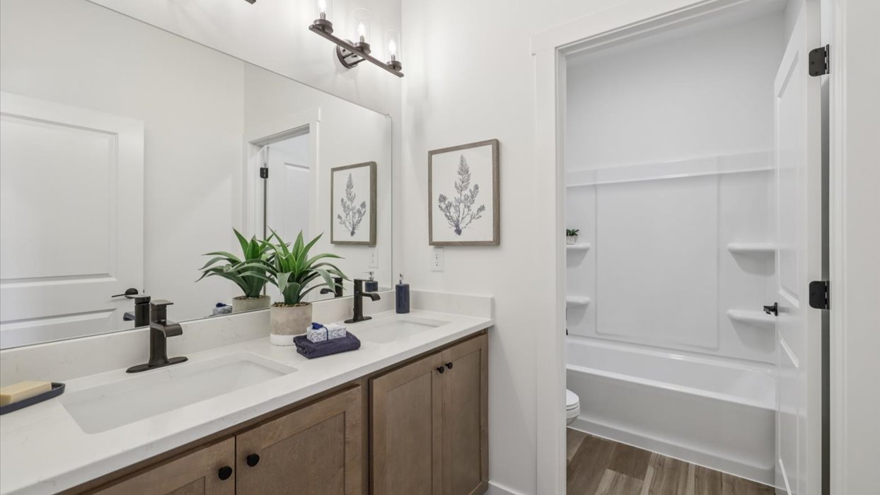 first bathroom with brown cabinets and bathrub