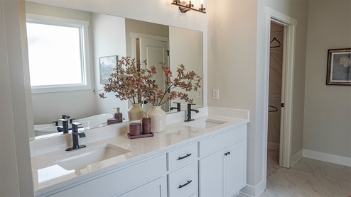 primary bathroom with large mirror and dual sinks