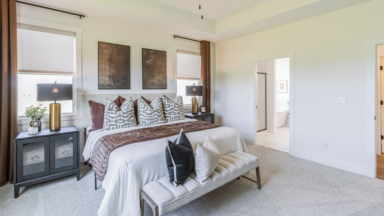 large primary bedroom with two small window and bed with two nightstands