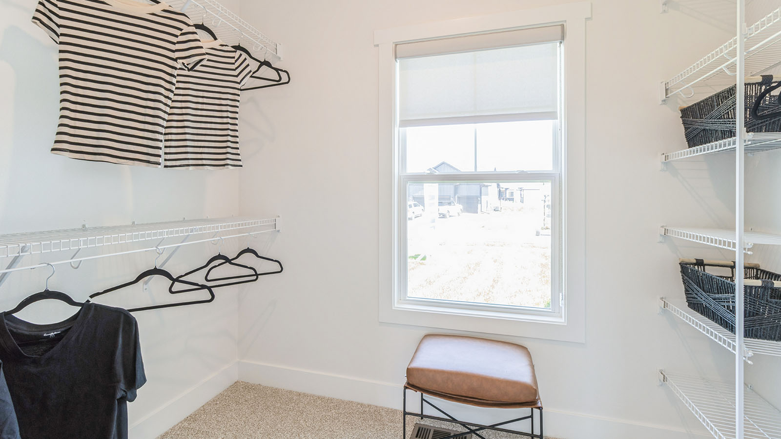 walk-in closet with small window and white wire shelving