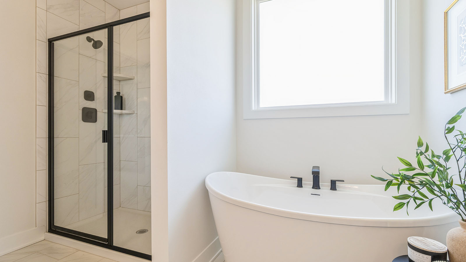 Freestanding tub and tile shower with glass doors in primary bathroom