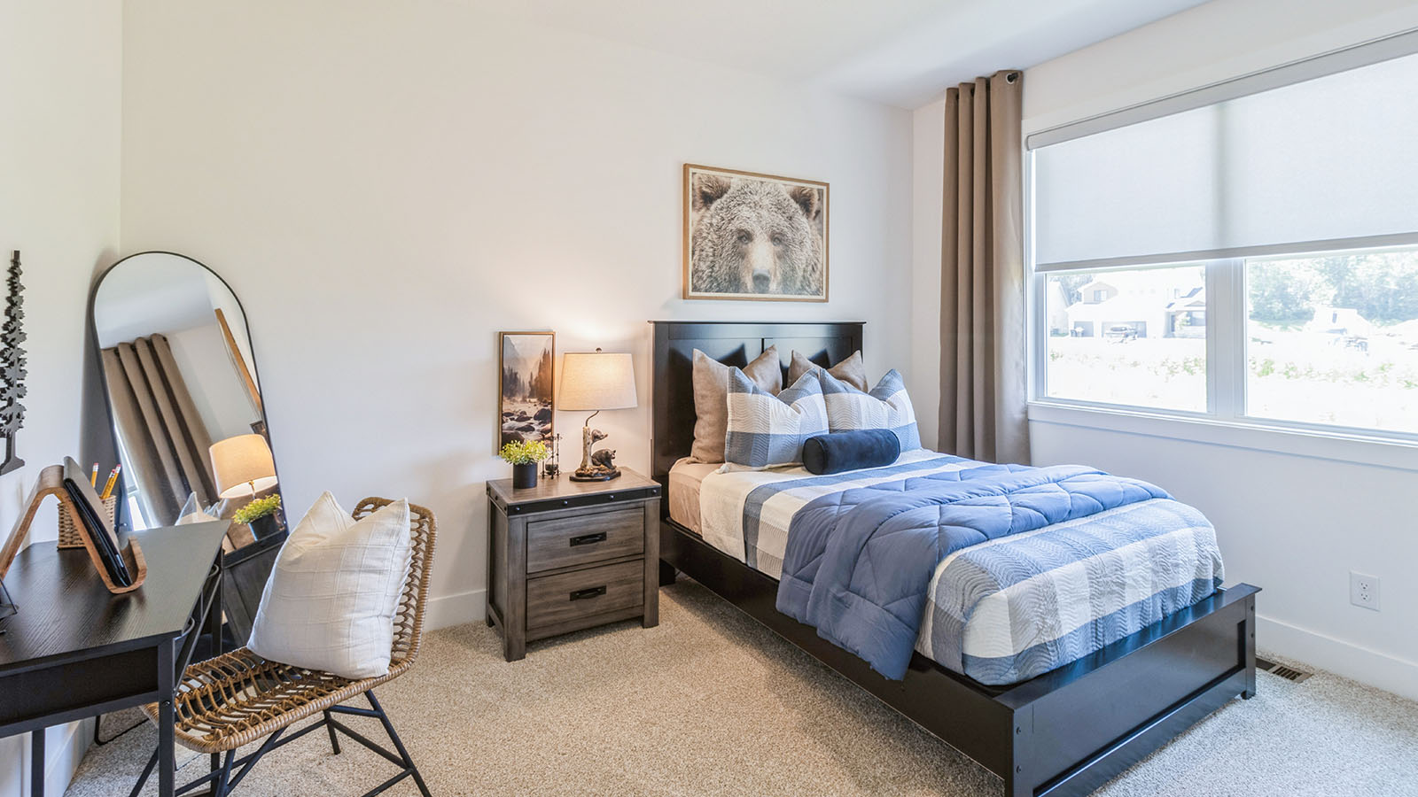 First bedroom with twin bed and black desk with floor length mirror
