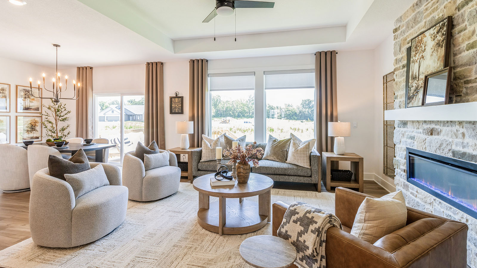 Open concept living room with large window and stone fireplace