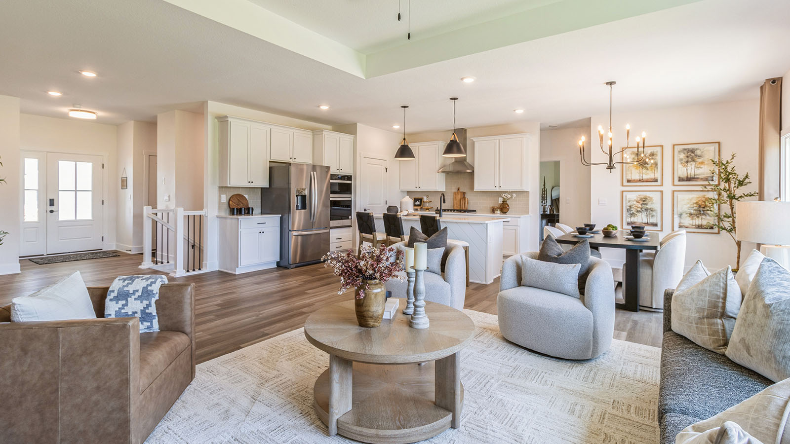 Spacious living room overlooking white kitchen and dining area