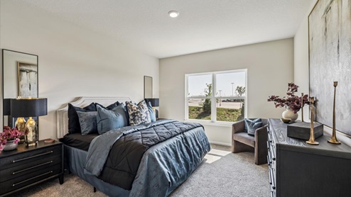 large primary bedroom with big window and bed