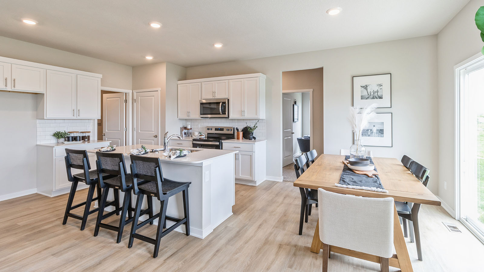 Dining area with table, chairs, and natural lighting off the kitchen.
