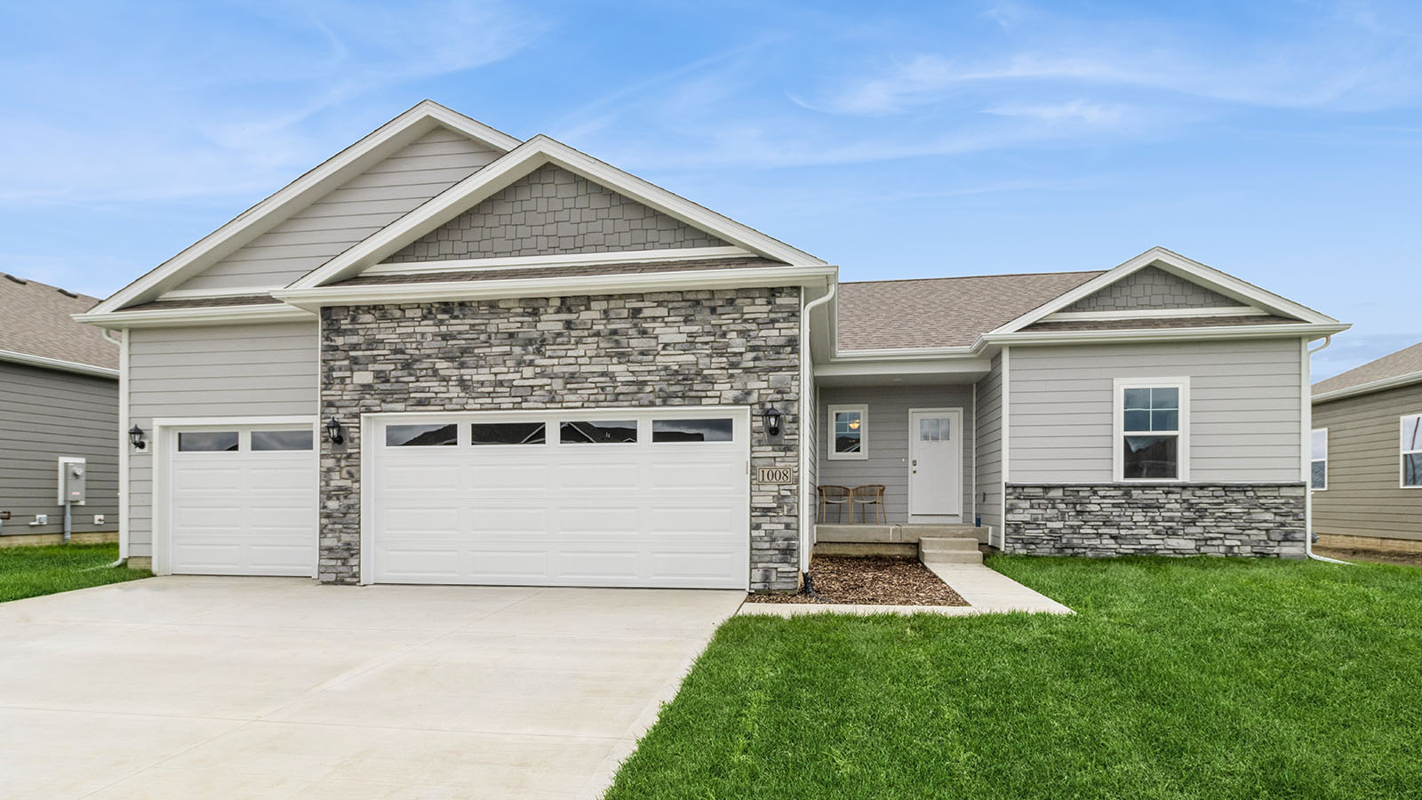 One story home with two car garage and paved driveway.