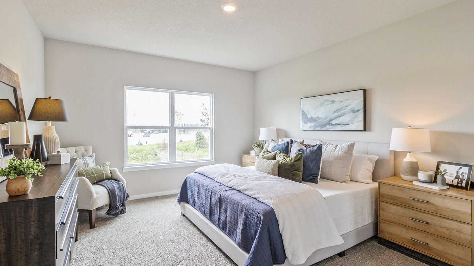 .Primary bedroom with carpet, large windows, and simple furnishings.
