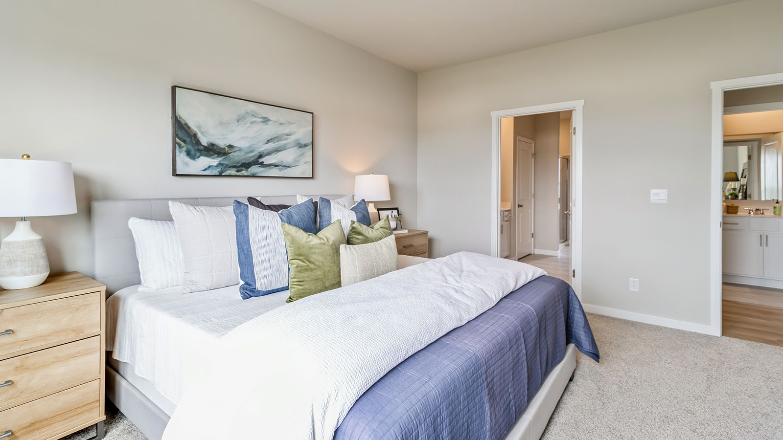 Primary bedroom with carpet, simple furnishings, and a bathroom attached.