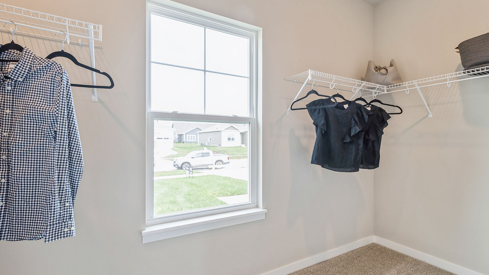 Spacious closet with hanging rod and a window.