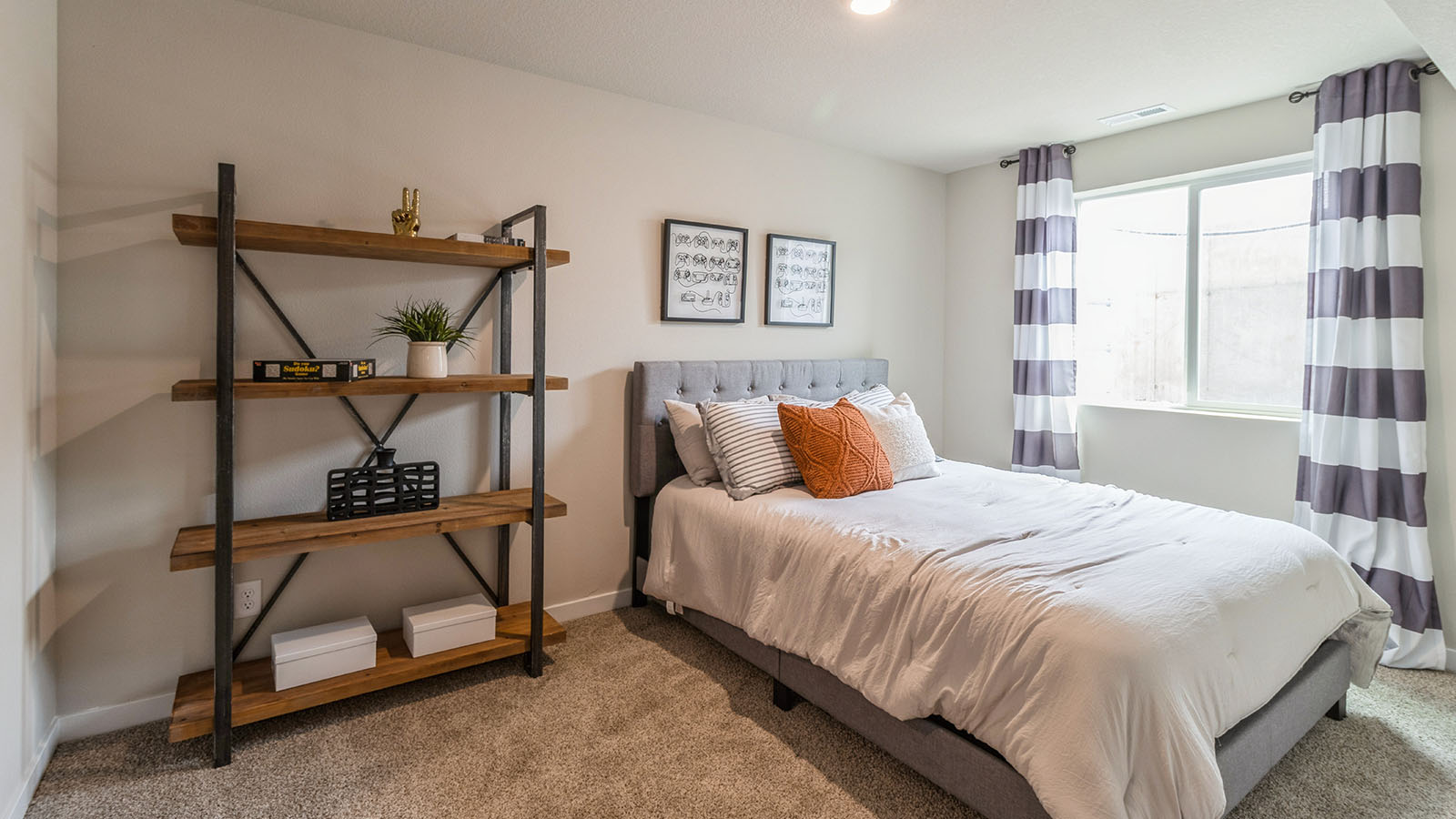 fourth bedroom in the basement with bed and wood shelving