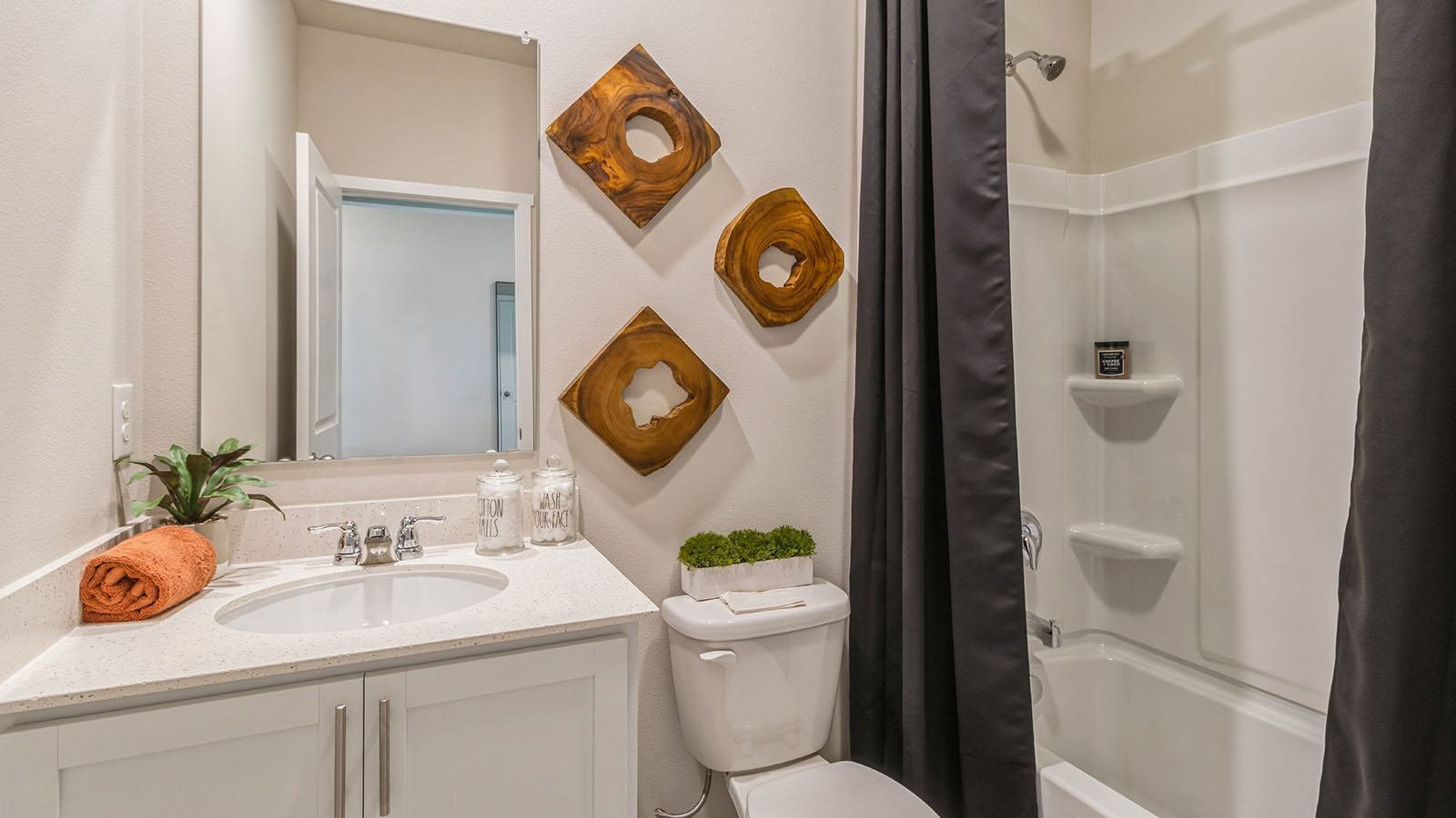 third bathroom in the basement with mirror and white cabinets and bathtub