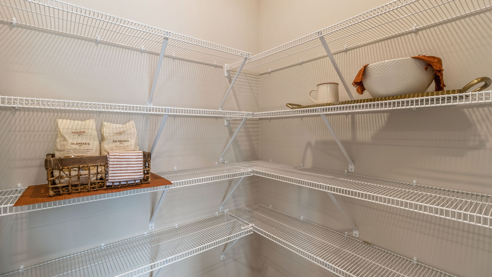 open walk-in pantry with white wire shelving