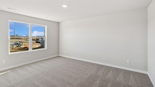 large primary bedroom with overhead lighting and grey carpet