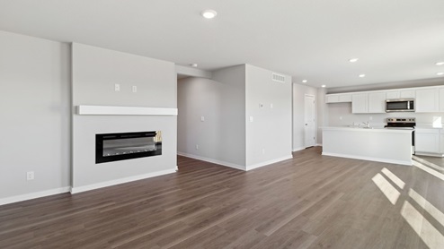 living room with electric fireplace overlooking dining area and kitchen