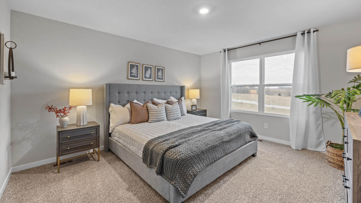 Primary bedroom with large window and white bed