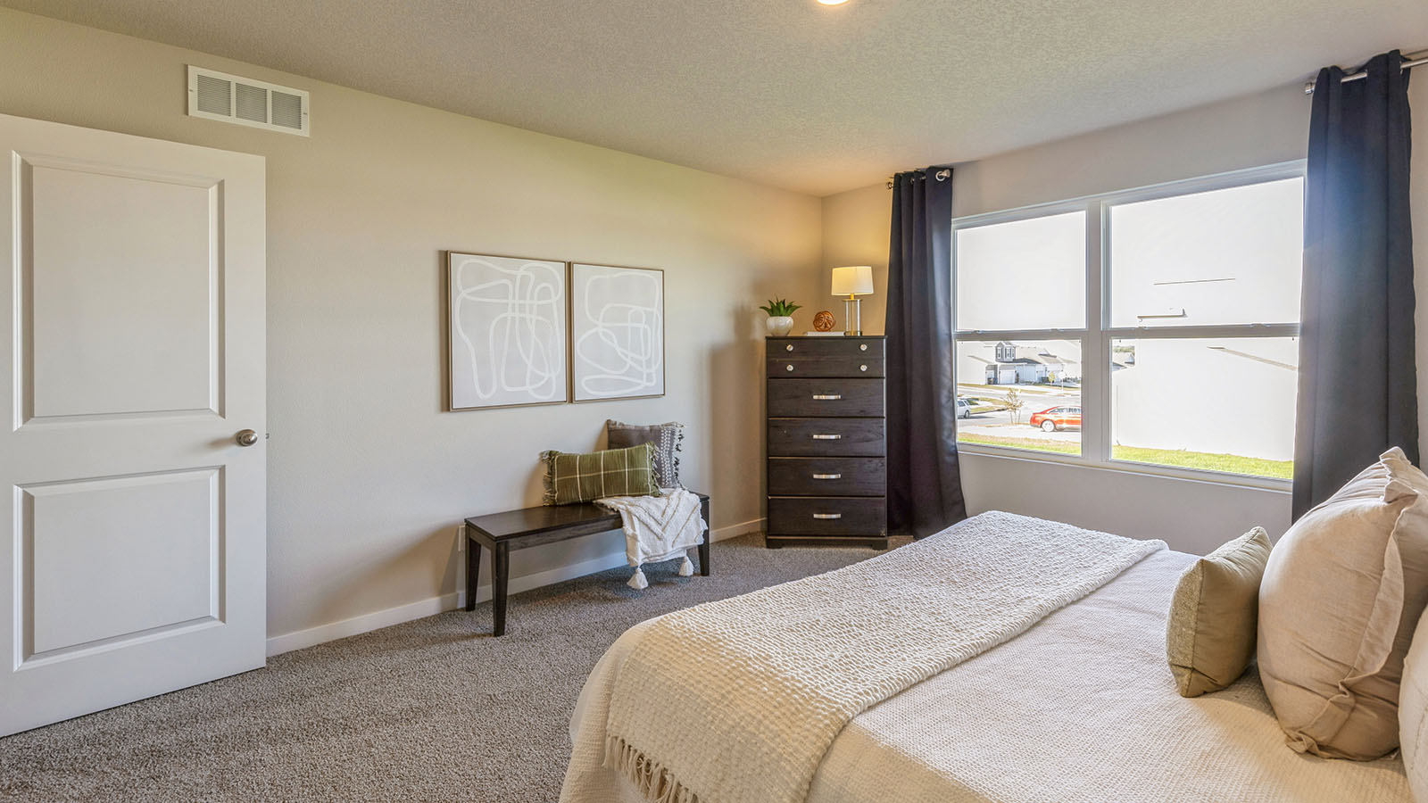 Primary bedroom with large window and seating area