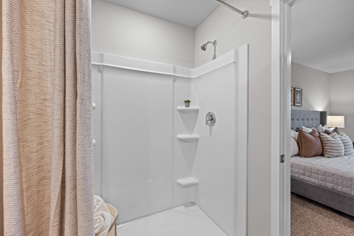 Shower with shelves in primary bathroom