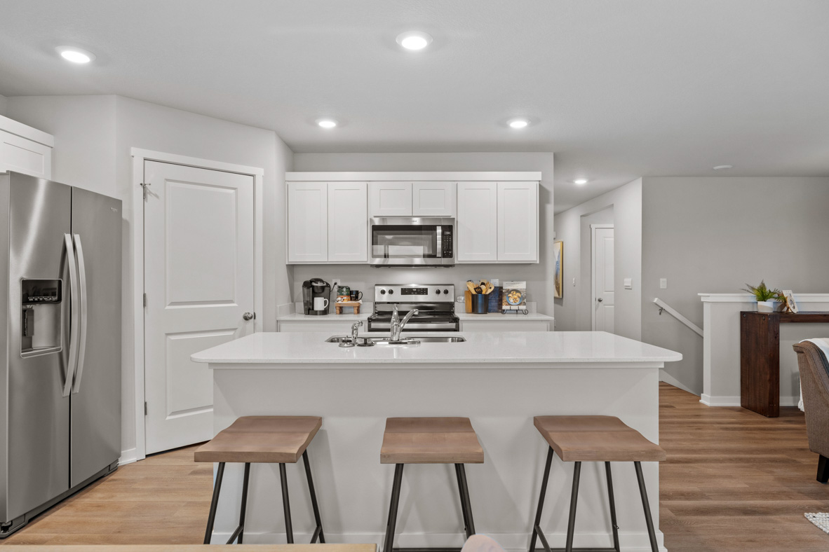 Modern kitchen with island and three brown barstools