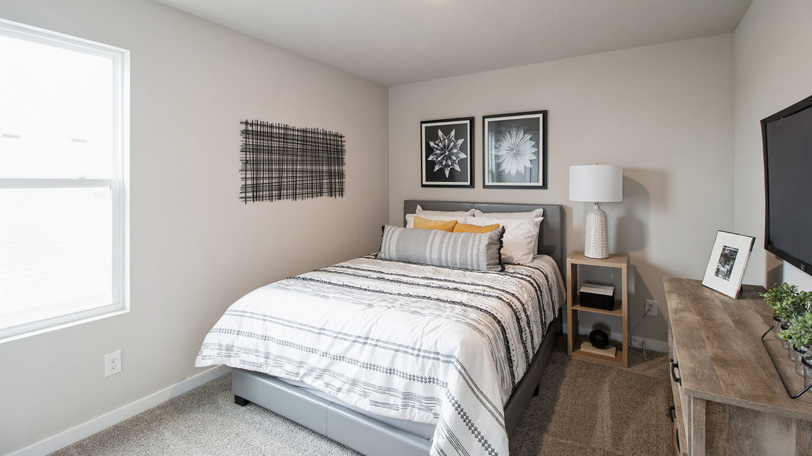 Second bedroom with grey bed and wood nightstands with dresser
