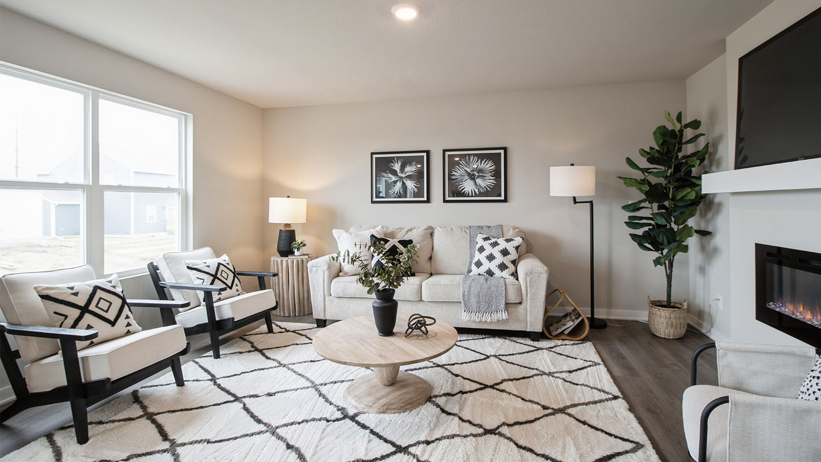 Bright living room with large window and white love seat with two white chairs