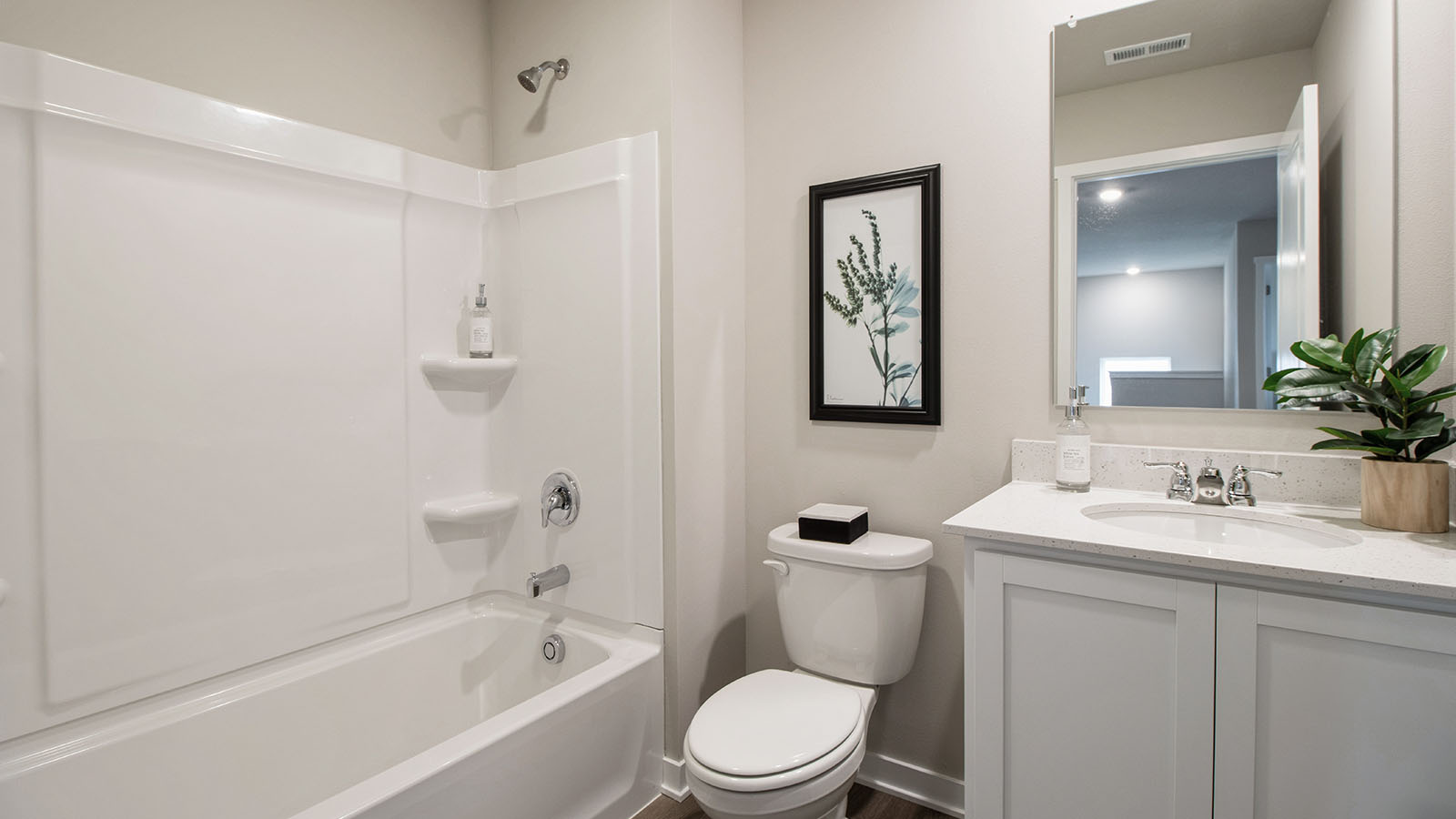 First bathroom with white cabinetry and shower and bathtub