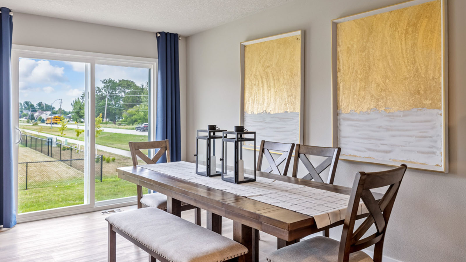 Dining room table with wood chairs next to sliding glass doors