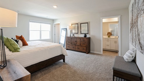 Primary bedroom with white bed and full length mirror